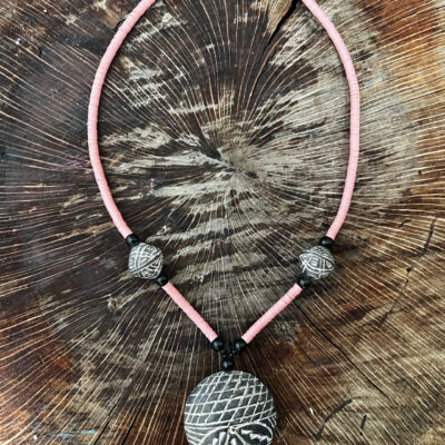 Collar con cuentas volcánicas grabadas, acrilicas en negro y planas en rosa.