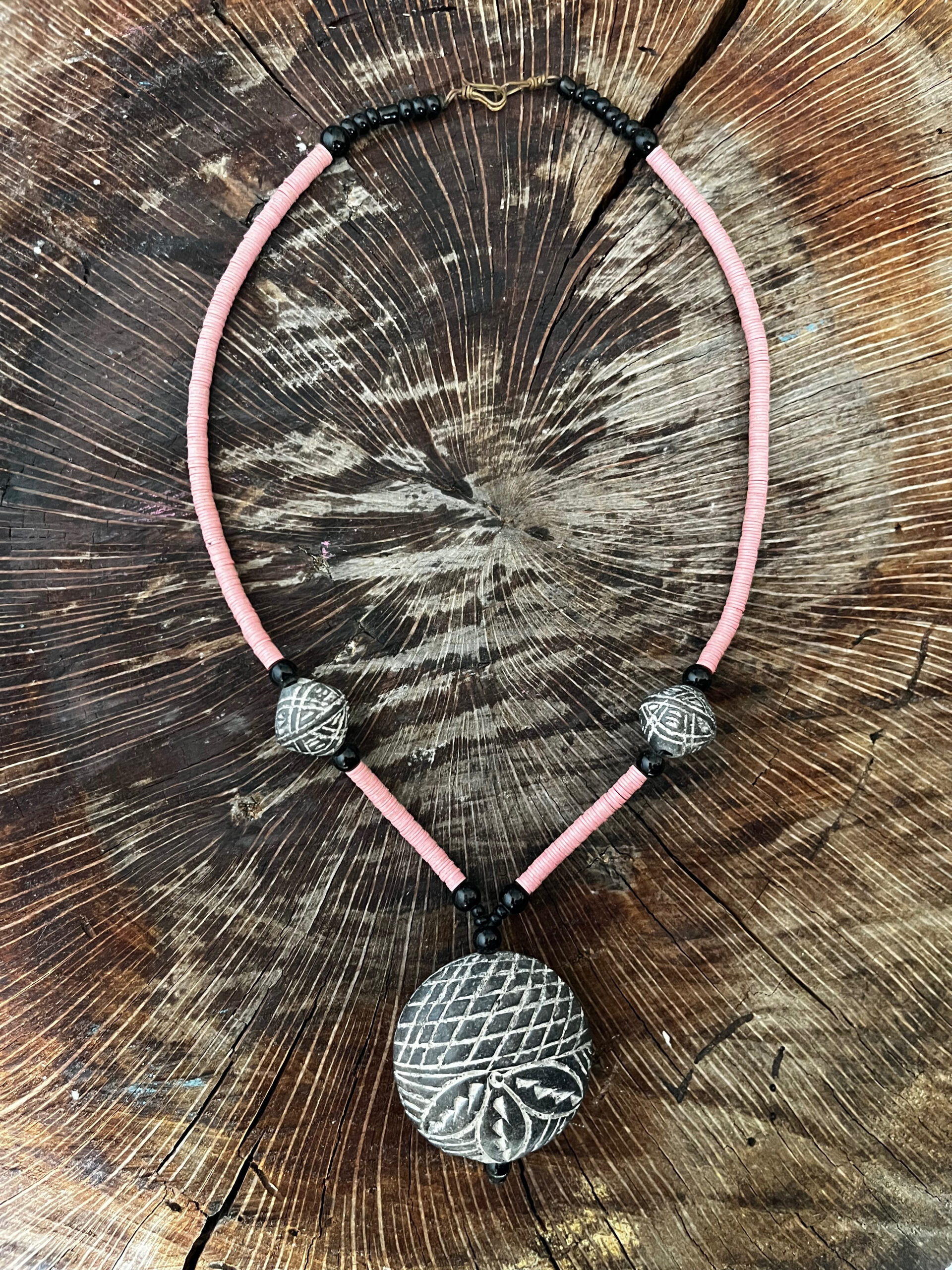 Collar con cuentas volcánicas grabadas, acrilicas en negro y planas en rosa.