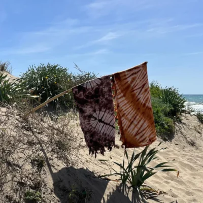 Pareos Étnicos  Ligeros, coloridos y llenos de personalidad, nuestros pareos étnicos hechos en Cabo Verde son el accesorio perfecto para el verano y para quienes aman vestir con estilo libre, auténtico y consciente. Cada pieza es elaborada a mano por artesanas locales que combinan tradición textil y creatividad en diseños únicos que reflejan la identidad cultural caboverdiana. Confeccionados en tejidos suaves, frescos y transpirables, estos pareos son ideales para llevar a la playa, la piscina o incluso como complemento para un look boho de día o de noche. Sus estampados se inspiran en motivos africanos y naturales, con una explosión de colores que aportan alegría y carácter a cualquier conjunto. Cada diseño es exclusivo, con pequeñas variaciones que hacen de cada pareo una pieza irrepetible.