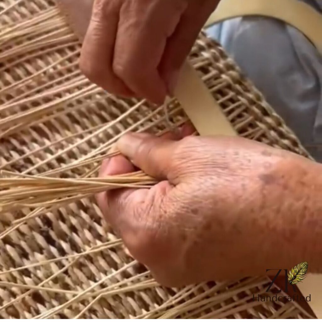 Manos tejiendo los capazos artesanales hebra a hebra.